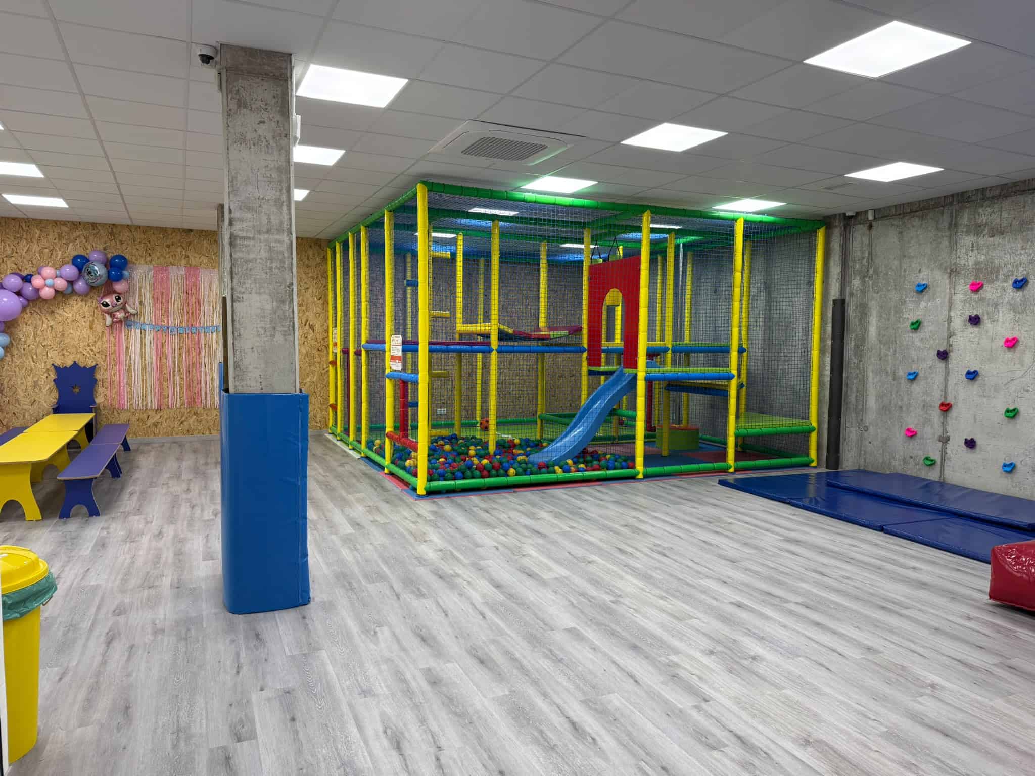 Sala principal con tobogán, rocódromo y mesas
